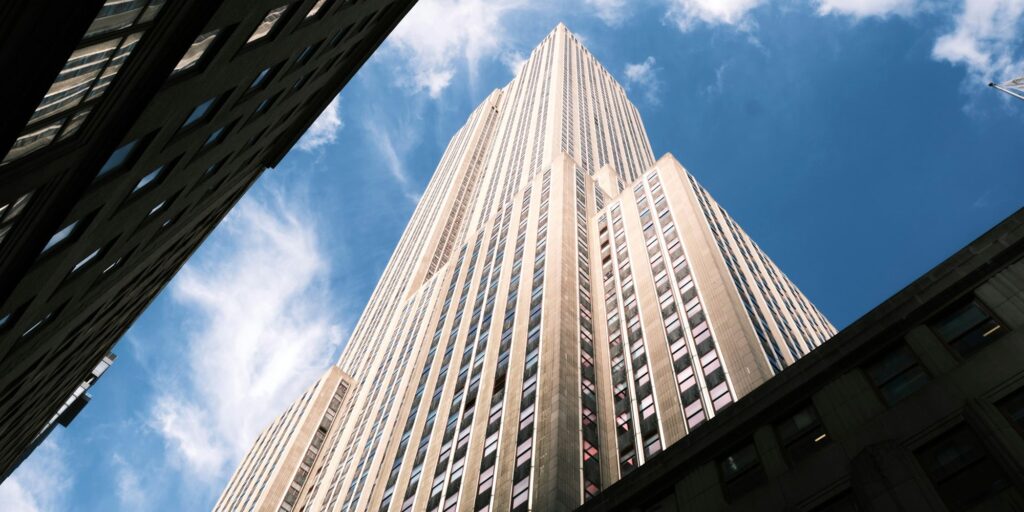 Looking up at the Empire State Building against a blue sky